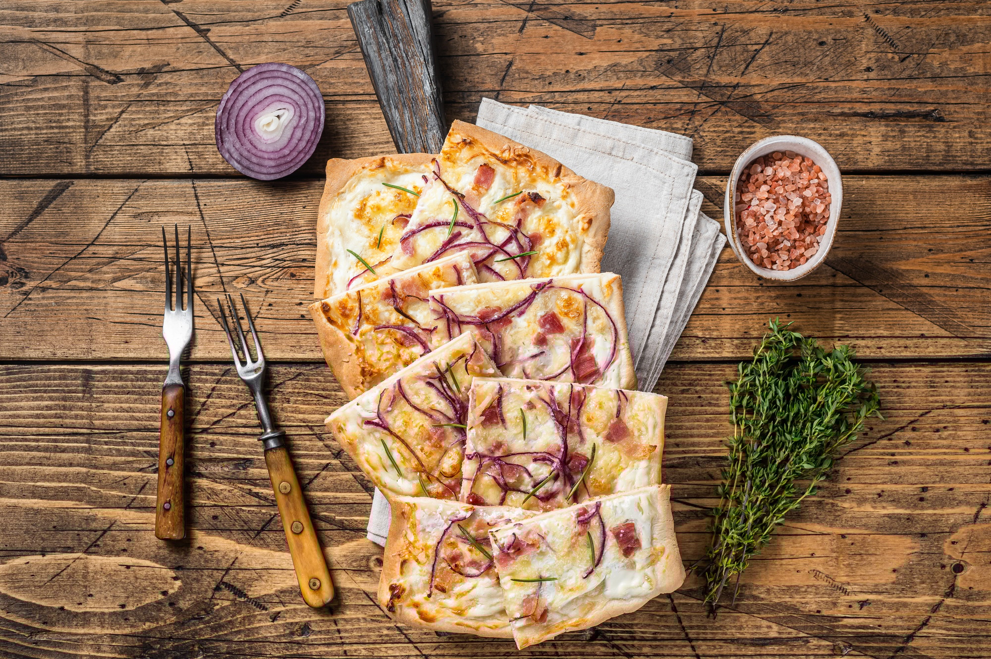 Flammkuchen or tarte flambee with cream cheese, bacon and onions.