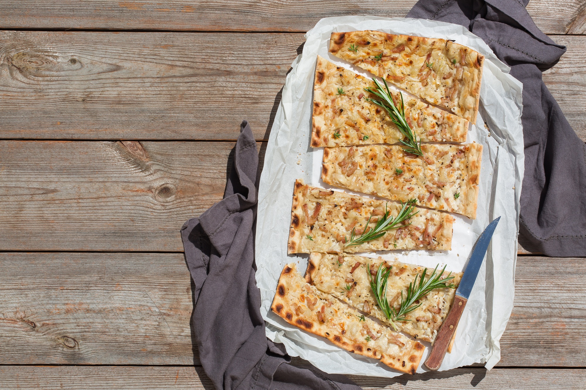 Flammkuchen, traditional German pizza with red onion, bacon, cream cheese