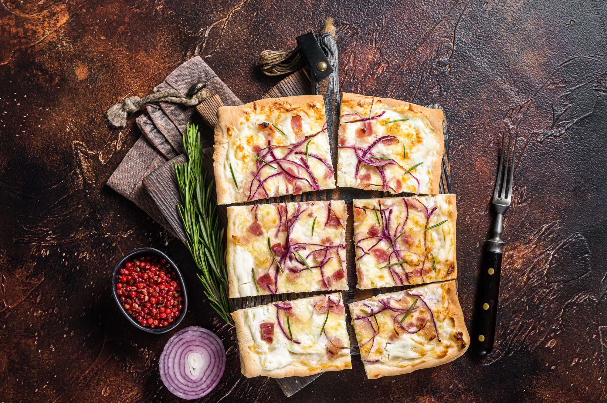 French tarte flambee with cream cheese, bacon and onions. Flammkuchen from Alsace region.
